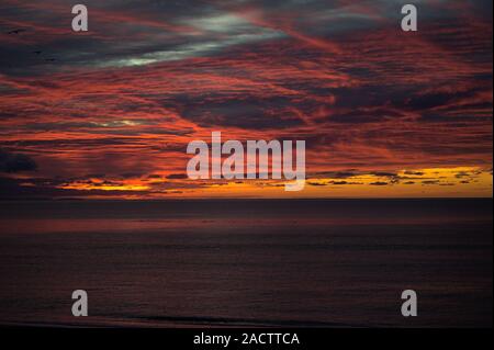 Fast apokalyptischen roten Himmel bei Nacht über der Irischen See in Aberystwyth an der Westküste von Wales Stockfoto