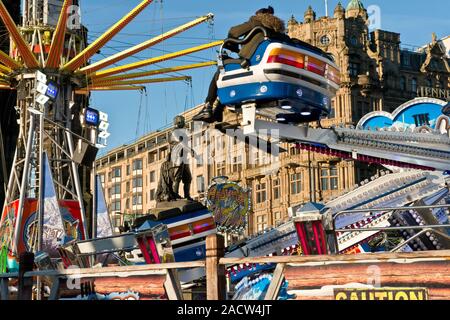 Yeti und Star Flyer Fahrgeschäfte. Edinburgh Weihnachtsmarkt und Fair. Jenners Kaufhaus auf der Princess Street im Hintergrund. Schottland Stockfoto