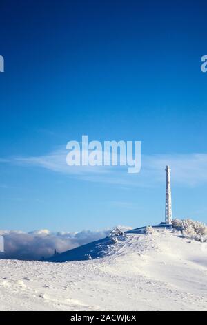 Eisige zellularen Antenne der Basisstation mit Schnee bedeckt. Zelle Aufstellungsort Turm auf moutain Hill. Telefon Netzwerk Transceiver und Kommunikationseinrichtungen auf Stockfoto