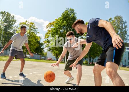 Sport, Freizeit Spiele und männliche Freundschaft Konzept - Gruppe der Männer oder Freunde spielen street Basketball Stockfoto