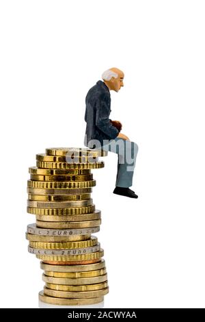 Rentner sitzt auf einem Haufen Geld Stockfoto