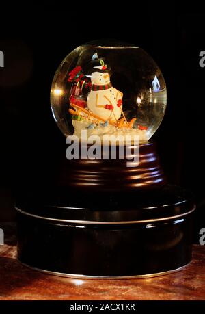 "Schneemann auf Schlitten "Snowglobe Stockfoto