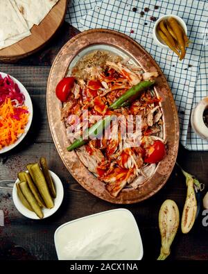 Gehackte Stücke gebratenes Hühnerfleisch in Tomatensauce und Essiggurken Stockfoto