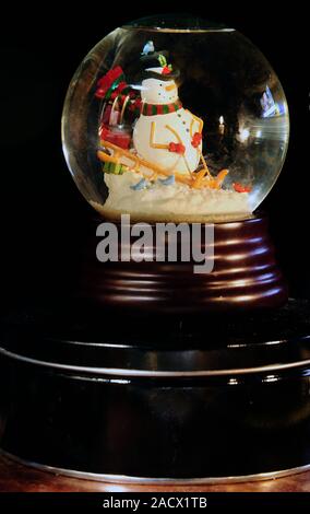 "Schneemann auf Schlitten "Snowglobe Stockfoto