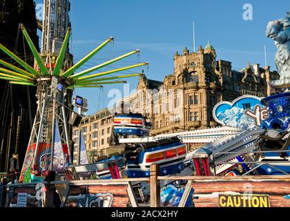 Yeti und Star Flyer Fahrgeschäfte. Edinburgh Weihnachtsmarkt und Fair. Jenners Kaufhaus auf der Princess Street im Hintergrund. Schottland Stockfoto