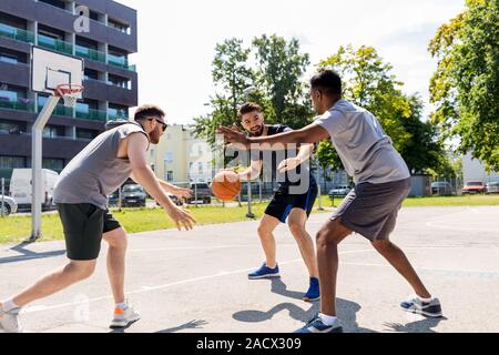 Sport, Freizeit Spiele und männliche Freundschaft Konzept - Gruppe der Männer oder Freunde spielen street Basketball Stockfoto