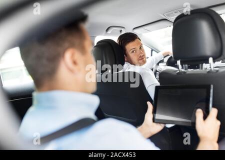 Transport, Fahrzeug und Personen Konzept - männliche Autofahrer auf der Beifahrerseite mit Tablet-PC Computer sitzen auf Rücksitz suchen Stockfoto