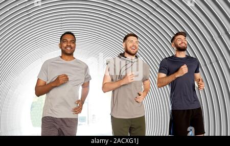 Fitness, Sport und gesunder Lebensstil Konzept - lächelnde junge Männer oder männliche Freunde im Tunnel Stockfoto