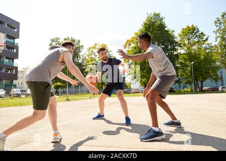 Sport, Freizeit Spiele und männliche Freundschaft Konzept - Gruppe der Männer oder Freunde spielen street Basketball Stockfoto