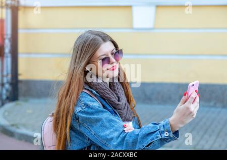 Eine Frau nehmen selfie auf einer Straße in einer europäischen Stadt. Porträt der attraktive junge Frau reist in die Stadt und mit Mobile Smartphone selfie Happ Stockfoto