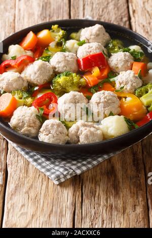 Gesunde Suppe mit Hähnchen Frikadellen und Gemüse close-up in einem Teller auf dem Tisch. Vertikale Stockfoto