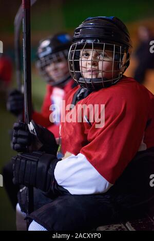 Kinder Eishockeyspieler auf Bank Stockfoto