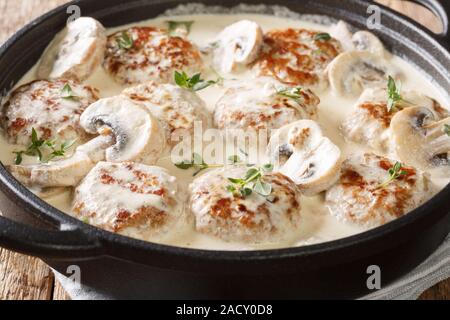 Heiße Frikadellen mit Champignons in cremige Käse Sauce mit Thymian in der Nähe serviert in einer Pfanne auf dem Tisch. Horizontale Stockfoto