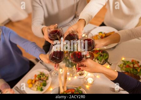 Feier, Feiertage und Personen Konzept - happy family Dinner Party, trinken Rotwein und Toasten zu Hause Stockfoto