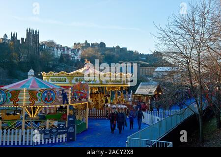 Das Edinburgh Castle, Weihnachtsmarkt und Fair. Karussell und Markt im Vordergrund. Schottland Stockfoto