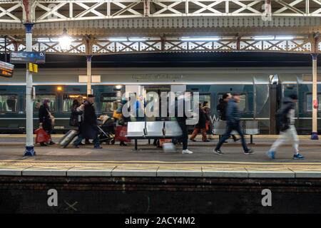 Die Passagiere schnell entlang der Plattform in Slough Bahnhof in gerade weg von einer späten Ankunft in Slough Stockfoto