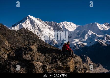 Gipfel des Mt. Cho Oyu, vom Gipfel des Gokyo Ri mit zwei Trekker saß oben auf gesehen Stockfoto