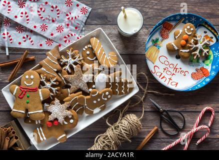 Eine Top-down-Sicht auf ein Teller voller Lebkuchen cookies mit verschiedenen Gegenständen, Geschenke für den Weihnachtsmann und Rentier für Heiligabend vorbereiten. Stockfoto