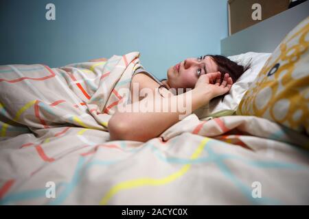 Seitenansicht einer verschlafenen jungen Frau leiden unter Kopfschmerzen, Augen geschlossen, im Bett zu Hause Stockfoto