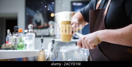 Barkeeper bricht Eis mit Holzhammer Stockfoto