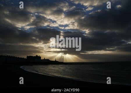 Aberystwyth Sonnenuntergang im November von der Promenade aufgenommen, die Gebäude in Silhouette zeigt Stockfoto