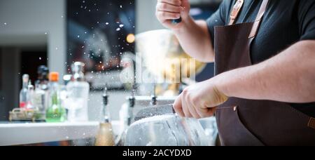 Barkeeper bricht Eis mit Holzhammer Stockfoto