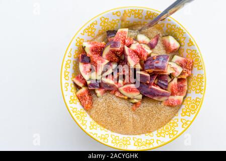 Amaranth Porridge zum Frühstück mit Feigen in einem gelben Schüssel, Ansicht von oben Stockfoto