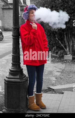 Frau vaping in Winchester, Hampshire, UK im November - Selektive Farbe, Farbe einblenden Stockfoto