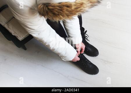 Mädchen setzt auf Stiefel in ein Schuhgeschäft. Demonstration von Frauen Stiefel. Saisonale Schuhe kaufen Stockfoto