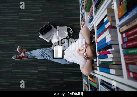 Studentin Studie in der Bibliothek, mit Tablet und die Suche nach Informationen im Internet Stockfoto