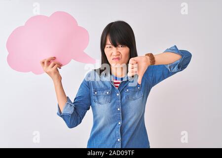 Junge schöne chinesische Frau mit Cloud Sprechblase über isoliert weißer Hintergrund mit Verärgerten Gesicht, negatives Vorzeichen zeigen Abneigung mit Daumen tun Stockfoto