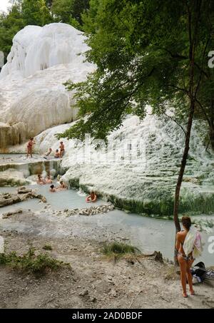 Die badegäste genießen die heißen Quellen und das weiße Kalzium Konkretion Einlagen bei Bagni San Filippo Wasserfälle, Castiglione d'Orcia, Toskana Italien Stockfoto