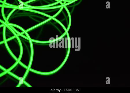 Giftig grün leuchtende Elektrolumineszenz Kabel mit unterschiedlichen Formen und Strukturen. Ein Netz von Kalk elektrolumineszente Faser, el Drähte und ungewöhnlich. Stockfoto