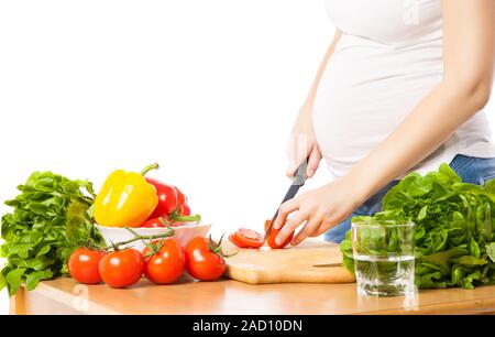 Nahaufnahme der schwangeren Frau schneiden Tomate Stockfoto