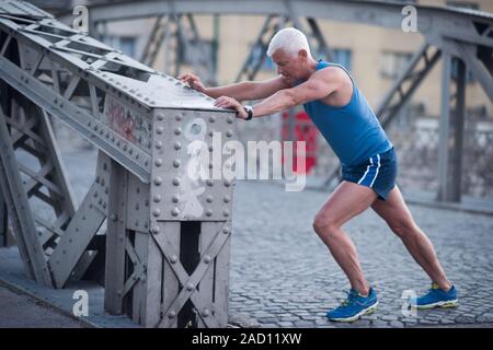 Schöner mann Stretching vor dem Joggen Stockfoto