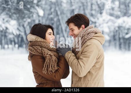 Lieben Freund Holding Freundin Hände wandern im verschneiten Wald Stockfoto