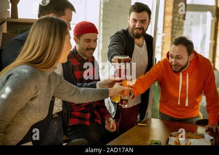 Glückliche Mitarbeiter feiern, während Unternehmen und Corporate Event. Junge kaukasier, in Freizeitkleidung Jubel und Laughting. Konzept der Office Kultur, Teamarbeit, Freundschaft, Feiertage, Wochenende. Stockfoto