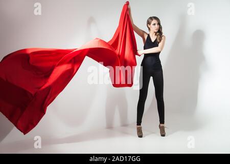 Seitenansicht der jungen Frau mit wehenden roten Tuch Stockfoto