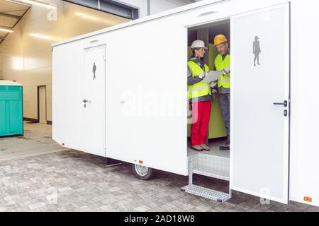 Arbeitern in einem Restroom Anhänger vor der Vermietung Stockfoto