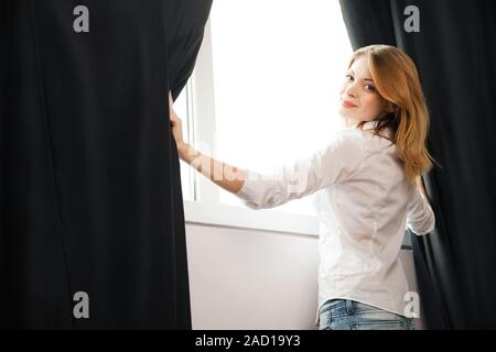 Mädchen öffnet die Vorhänge und entspannen Sie im Morgen Stockfoto