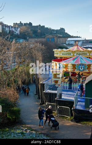 Das Edinburgh Castle, Weihnachtsmarkt und Fair. Karussell und Markt im Vordergrund. Schottland Stockfoto