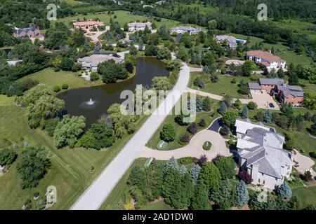 Luftaufnahme von einem luxuriösen Nachbarschaft mit großen Wohnungen und ein Teich in einem Chicago Vorstadtnachbarschaft im Sommer. Stockfoto