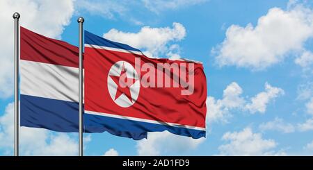Niederlande und Nordkorea Fahne im Wind gegen Weiße bewölkt blauer Himmel zusammen. Diplomatie Konzept, internationale Beziehungen. Stockfoto