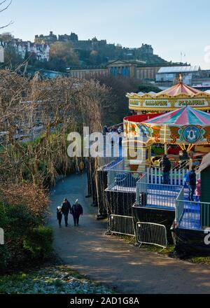 Das Edinburgh Castle, Weihnachtsmarkt und Fair. Karussell und Markt im Vordergrund. Schottland Stockfoto