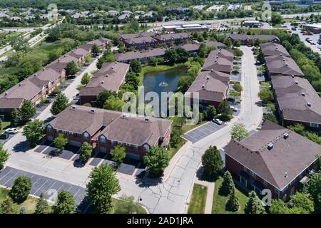 Luftaufnahme von einer Hotelanlage im Stadthausstil mit einem kleinen Teich in einem Chicago Vorstadtnachbarschaft im Sommer. Stockfoto