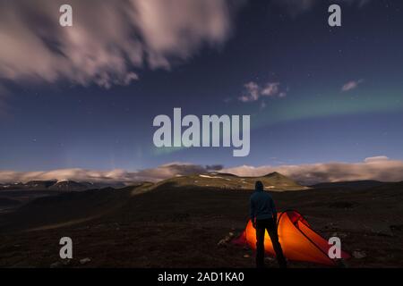 Männer neben seinem Zelt mit Northern Lights, Rapa Tal, Lappland, Schweden Stockfoto