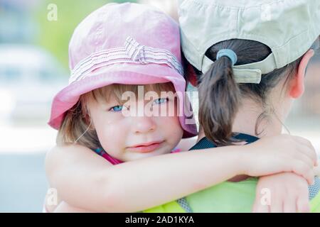 Traurige kleine Mädchen ihre Mutter umarmt Stockfoto