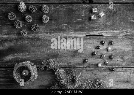 Schwarzweiß-Bild von Holiday Einstellung der Weihnachtsverzierungen, Kugeln, Kegel und Kerzen auf rustikalen Holztisch. Ansicht von oben mit der Kopie. Stockfoto