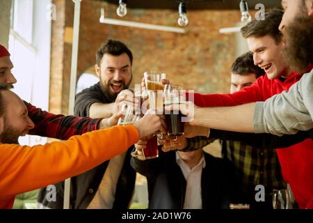 Glückliche Mitarbeiter feiern, während Unternehmen und Corporate Event. Junge kaukasier, in Freizeitkleidung Jubel und Laughting. Konzept der Office Kultur, Teamarbeit, Freundschaft, Feiertage, Wochenende. Stockfoto
