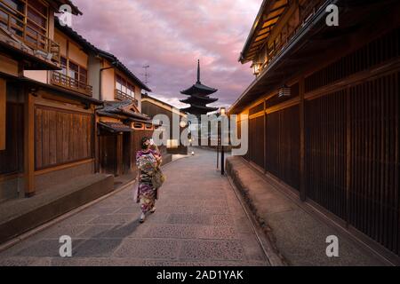 Kyoto, Japan - 4. November 2018: eine Frau, gekleidet wie ein Maiko (lehrling Geisha) unter ein Foto von Yasaka Pagode von Hokan-ji Tempel, Kyoto Stockfoto